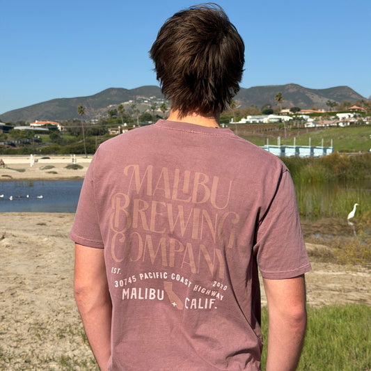 Person wearing a Malibu Brewing Company t-shirt with a scenic background